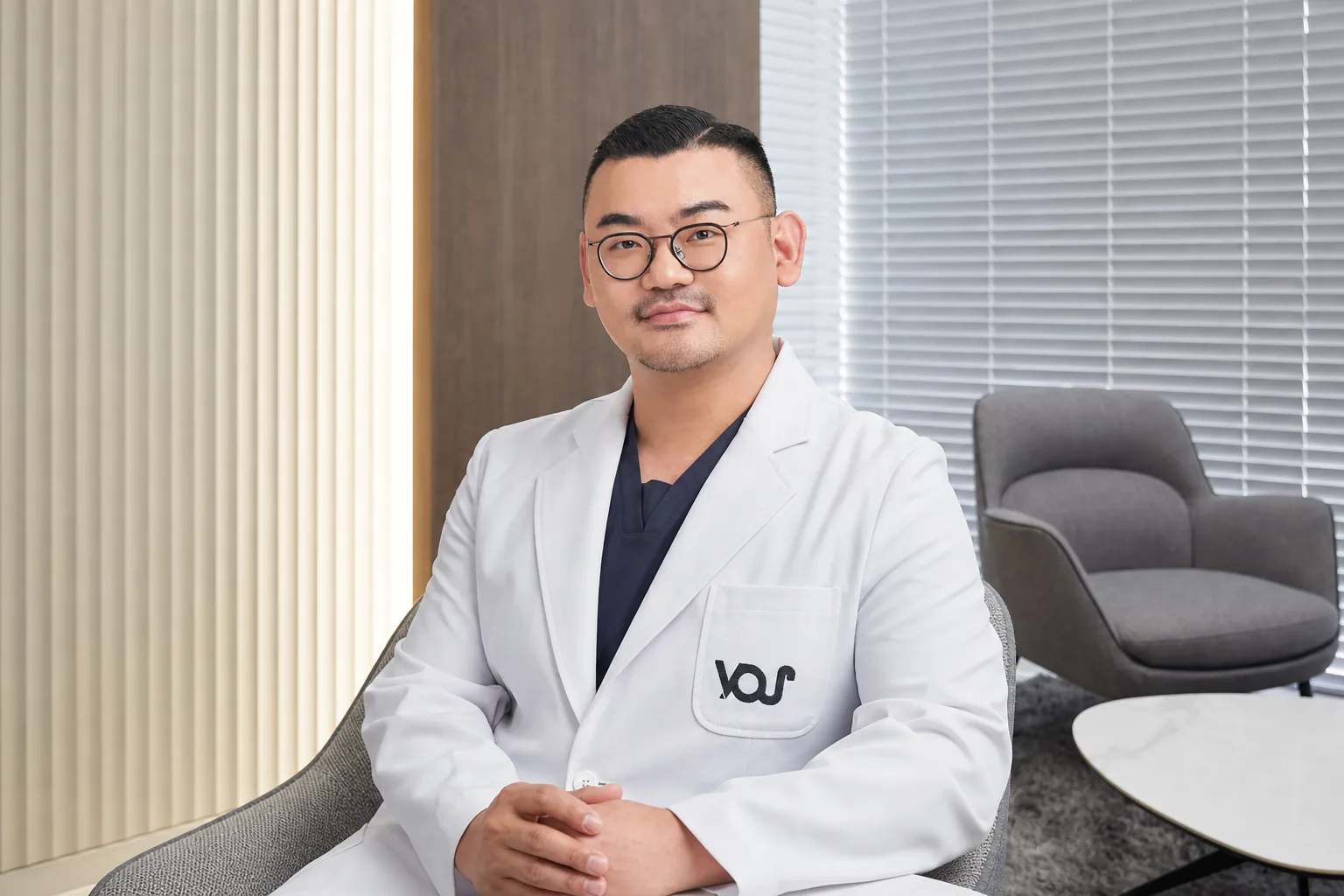 Dr. Hongseok Kim, board-certified dermatologist, at his consultation desk in the VOS consultation room, Gangnam
